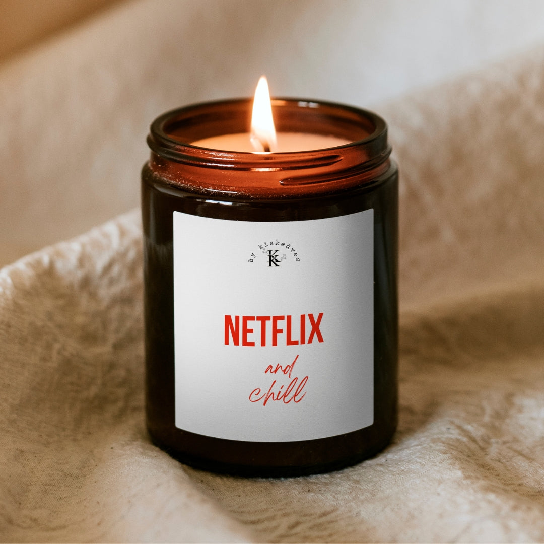 Sójová sviečka Kiskedves Netflix and chill v hnedom pohári, s horiacim plameňom, na mäkkej deke.