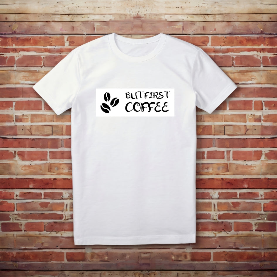 Tričko Kiskedves But first coffee s čistým nápisom BUT FIRST COFFEE a dvoma kávovými zrnkami, nafotené naležato.