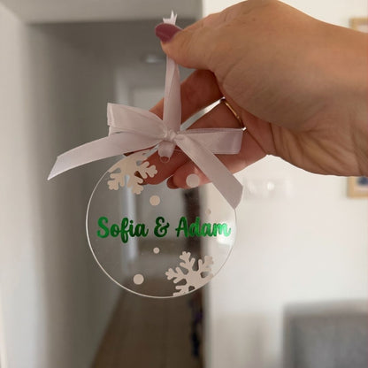 Akrylová ozdoba držaná v ruke, so zeleným nápisom a vločkami