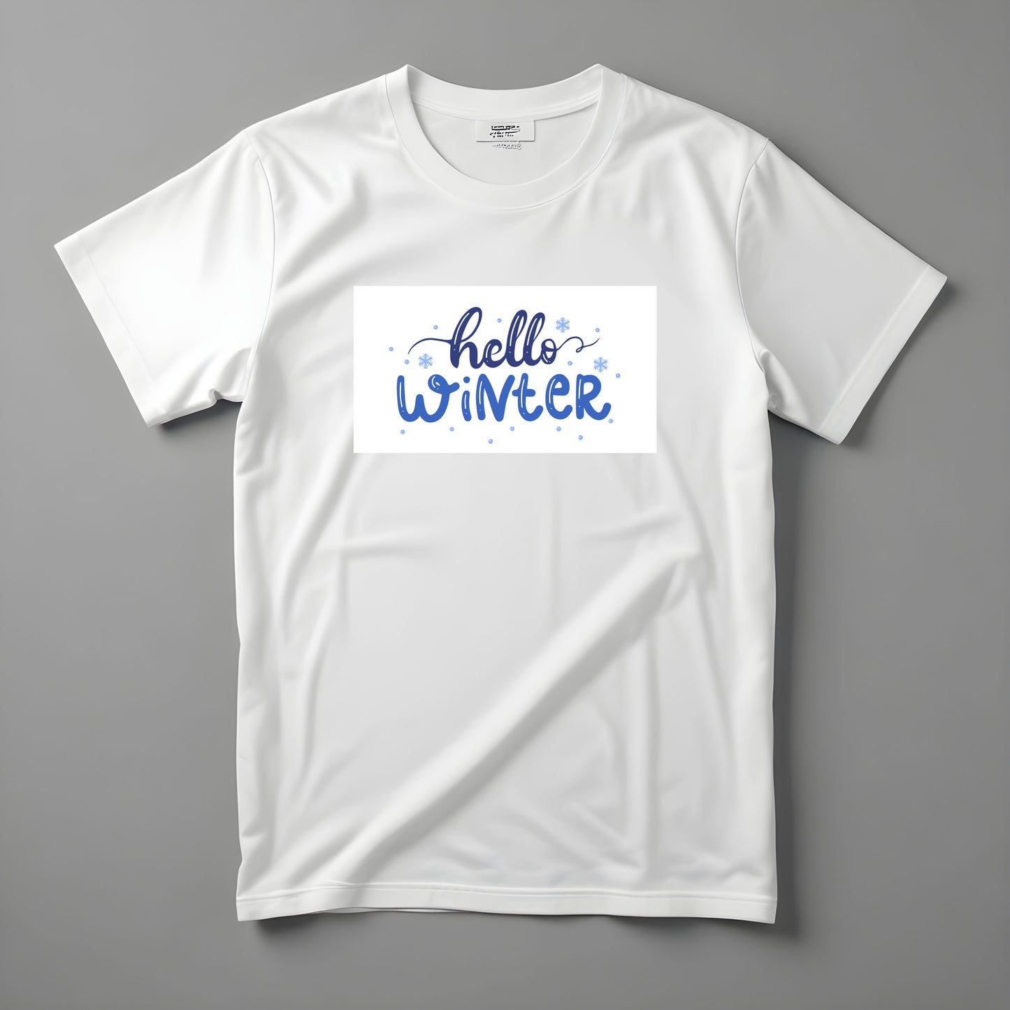 Tričko Kiskedves Hello Winter s modrým ručne písaným nápisom hello winter a drobnými vločkami, nafotené naležato.