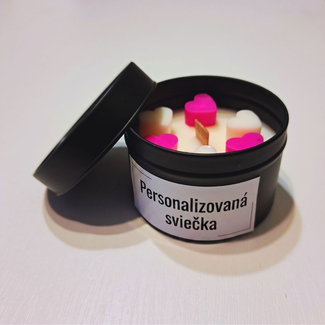 Otvorená čierna plechová dóza so sójovou sviečkou, ružovými a bielymi voskovými srdiečkami a dreveným knôtom, so štítkom „Personalizovaná sviečka“