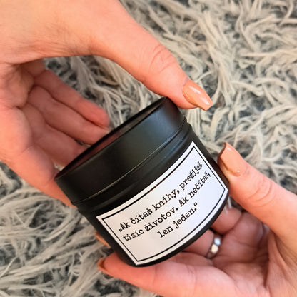Kvetinová sviečka Kiskedves v čiernej plechovej dóze držaná v dlaniach, so štítkom s textom